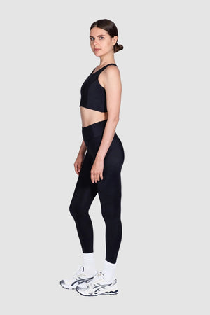 Woman wearing a black athletic outfit on a white background