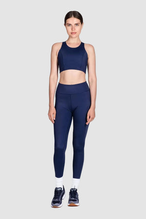 Woman wearing a navy blue athletic outfit on a white background