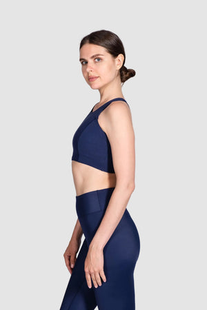 Woman wearing a navy blue athletic outfit on a white background