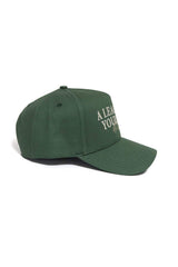 The ALOYO Hat from No Rivals’ No Rivals Collection is a dark green cotton baseball cap with a curved brim and white embroidered front text, shown angled to display both the side and part of the front panel.