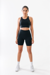 Woman wearing a black athletic outfit on a white background