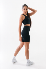 Woman wearing a black athletic outfit on a white background