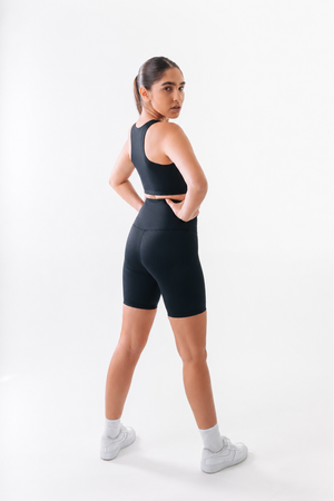 Woman wearing a black athletic outfit on a white background