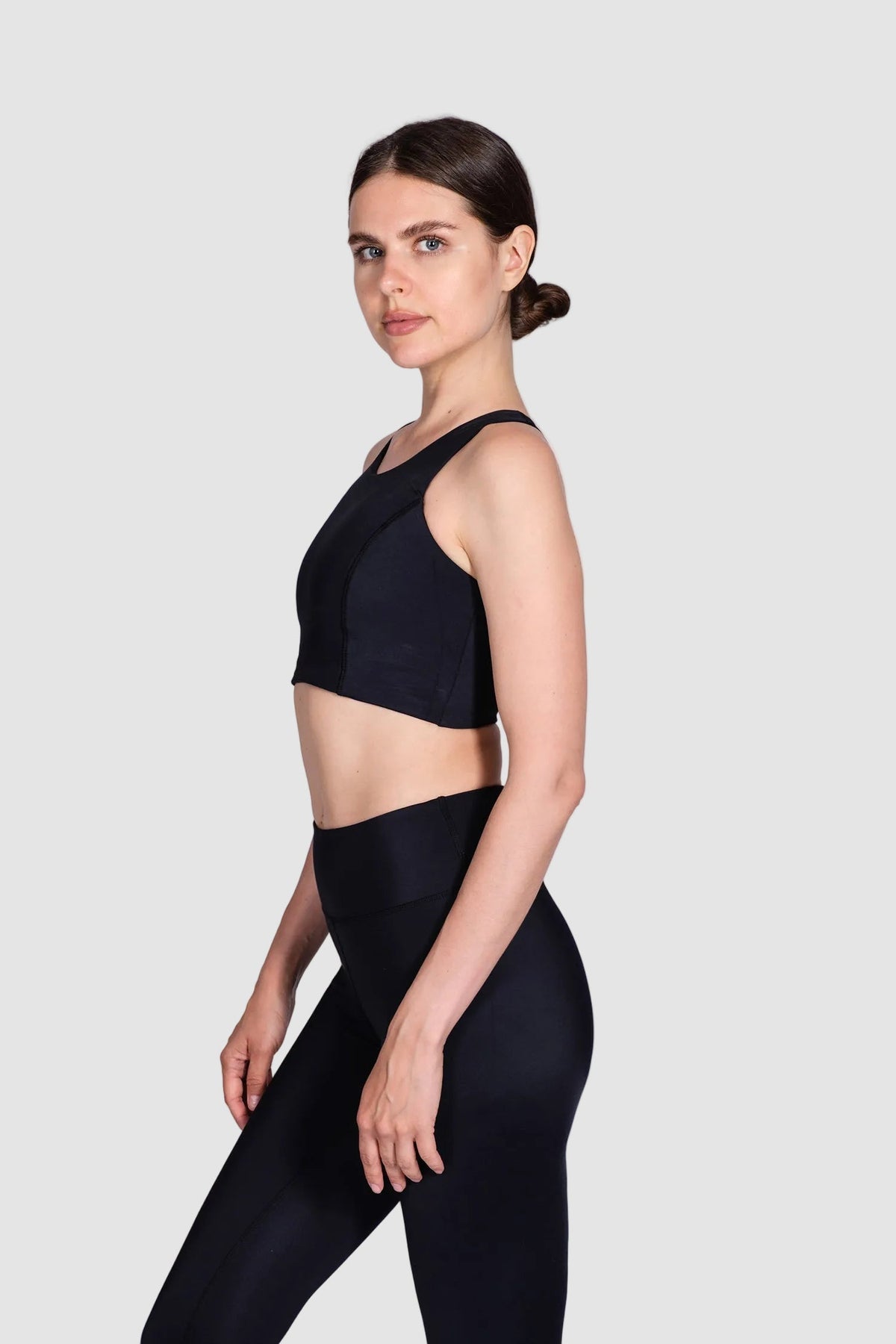 Woman wearing a black athletic outfit on a white background