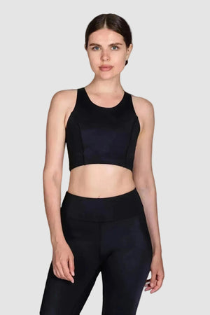Woman wearing a black sports bra and leggings on a white background