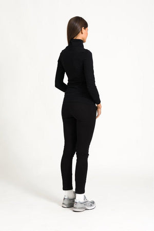 Model back view of black zip top outfit against a white background.