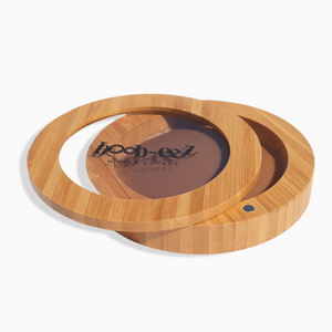Product shot of the Boob-eez Bamboo Compact with Dark tint Headlight Hiders inside, close-up side shot showing the beautiful wood grain, magnetic closure, and translucent window to display the Headlight Hiders inside