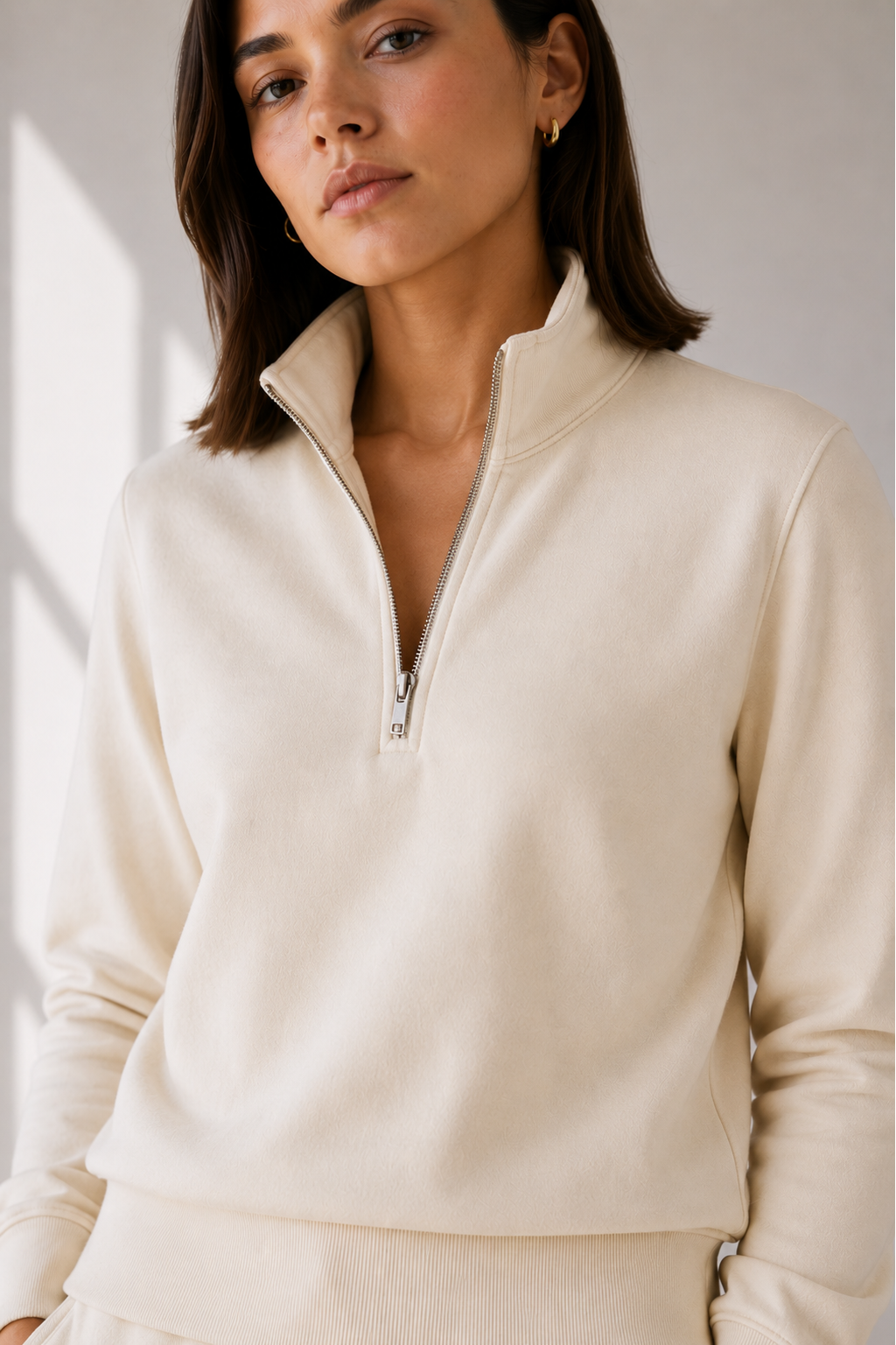 Close up view of model in cream sweatshirt.