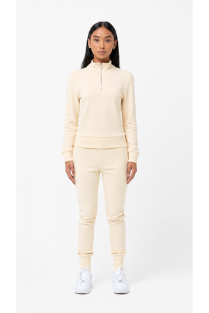 Person wearing a cream-colored tracksuit on a white background