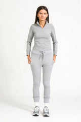 Model in grey zip top against white background.
