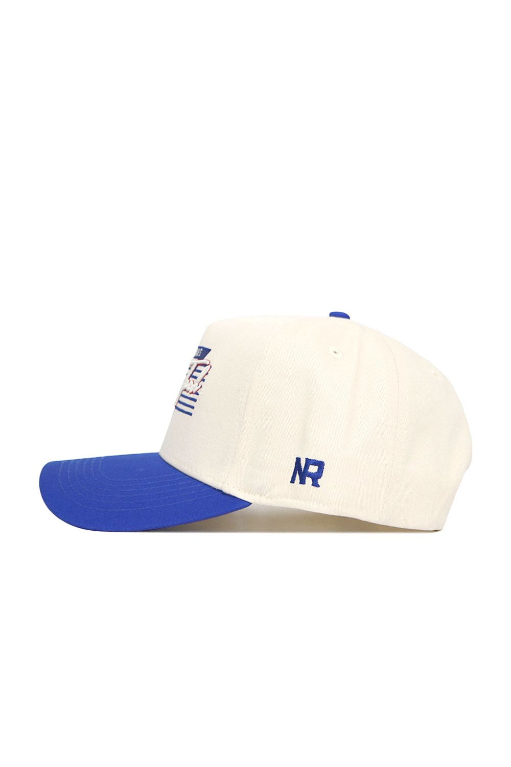 The LA Tech Triangle Game Cap Hat by No Rivals is a white structured baseball cap with a blue brim, blue NR embroidery on the side, and a bold blue and red graphic on the front.