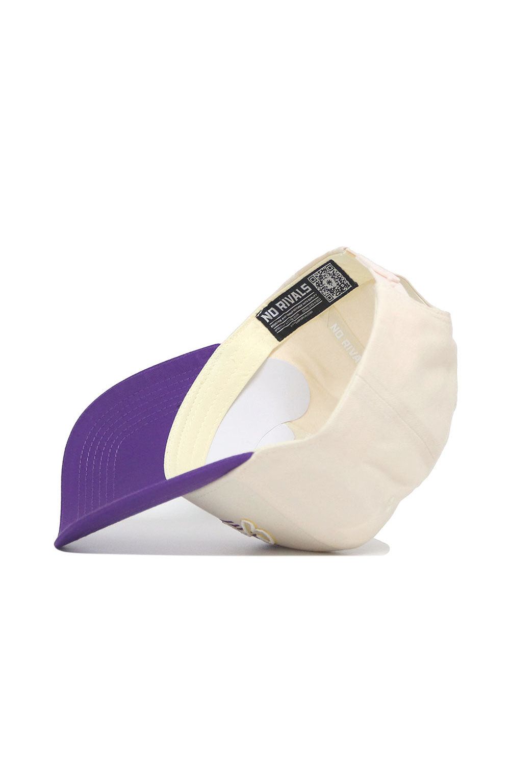 The ECU (East Carolina) Triangle Game Cap Hat by No Rivals is shown from a side angle, displaying its cream color, purple brim, structured fit, and interior. A black NO RIVALS label and a QR code are visible inside.