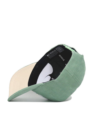 The Iowa Corduroy Hat - Structured - Spring Green (B2B) by No Rivals is pictured upside down, showcasing its beige inner brim and black interior lining with white "NO RIVALS" text.