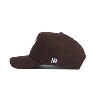 The EWU Americano Hat by No Rivals is a dark brown snapback shown from the side, featuring white embroidered NR lettering above the adjustable strap. Made from high-quality cotton for a comfortable, structured fit.