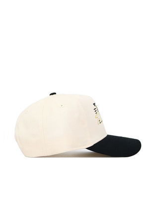 The No Rivals App State Triangle Game Cap Hat features a cream color, black curved brim, and structured fit as seen from the side. A partially visible black and yellow embroidered design is on the front.