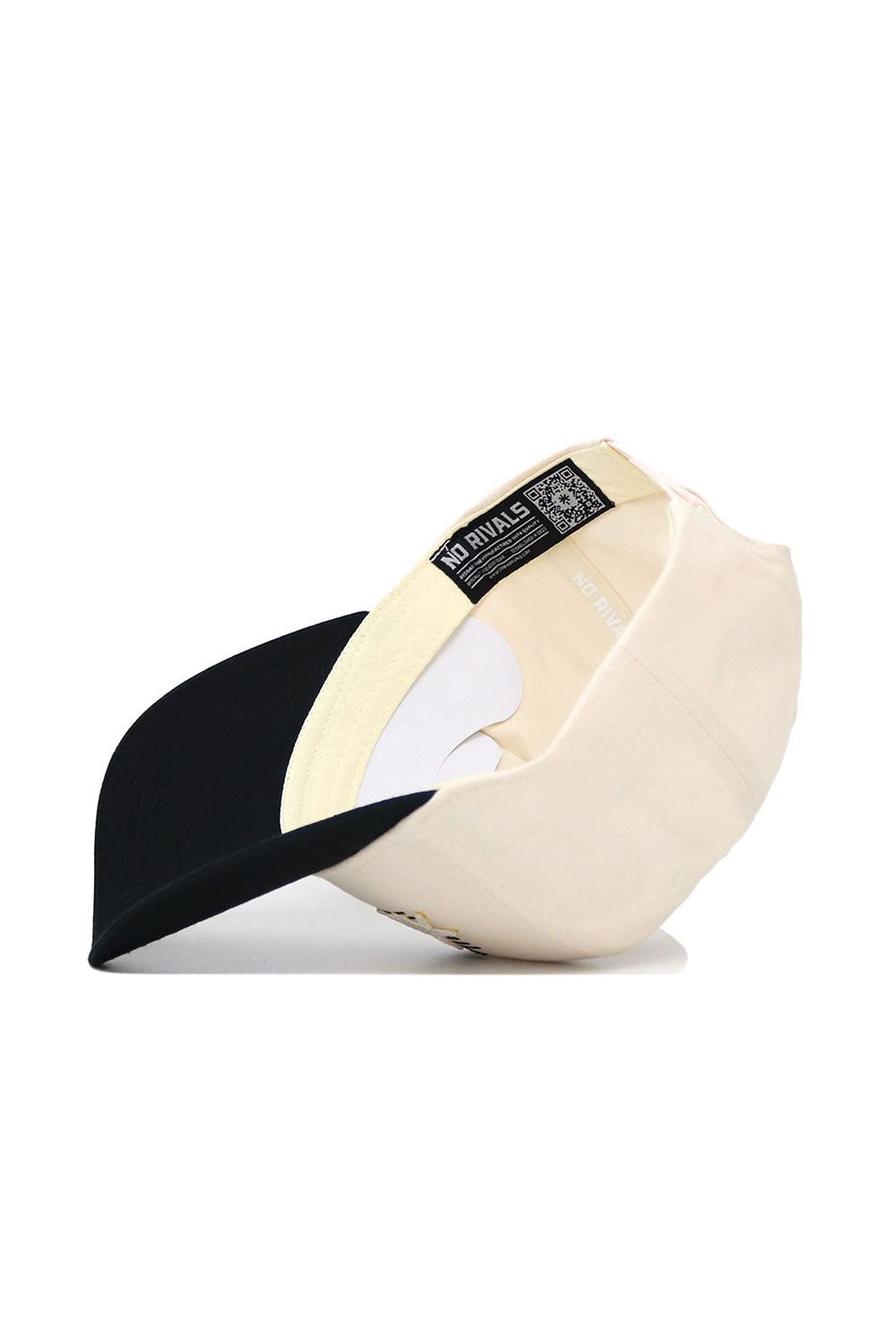 A cream App State Triangle Game Cap Hat by No Rivals is shown upside down, revealing its black brim, inner sweatband, and a NO RIVALS tag inside the crown.