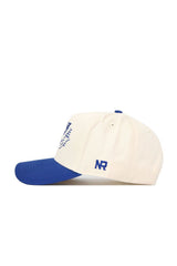 The No Rivals Kentucky Triangle Game Cap Hat is a white cap with a blue brim, top button, and NR embroidery on the side, offering a structured fit to maintain its shape.