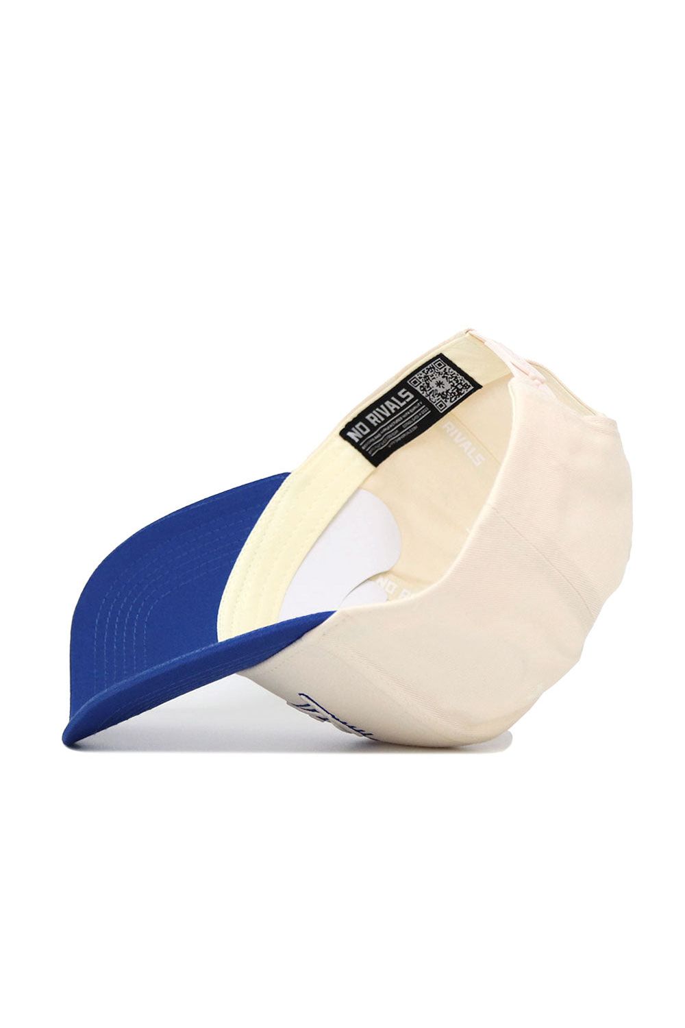 The No Rivals Kentucky Triangle Game Cap Hat is shown cream-colored with a blue brim, flipped to reveal interior labels and a black "NO RIVALS" tag. Visible features include the adjustable strap, seam details, and structured snap back fit.