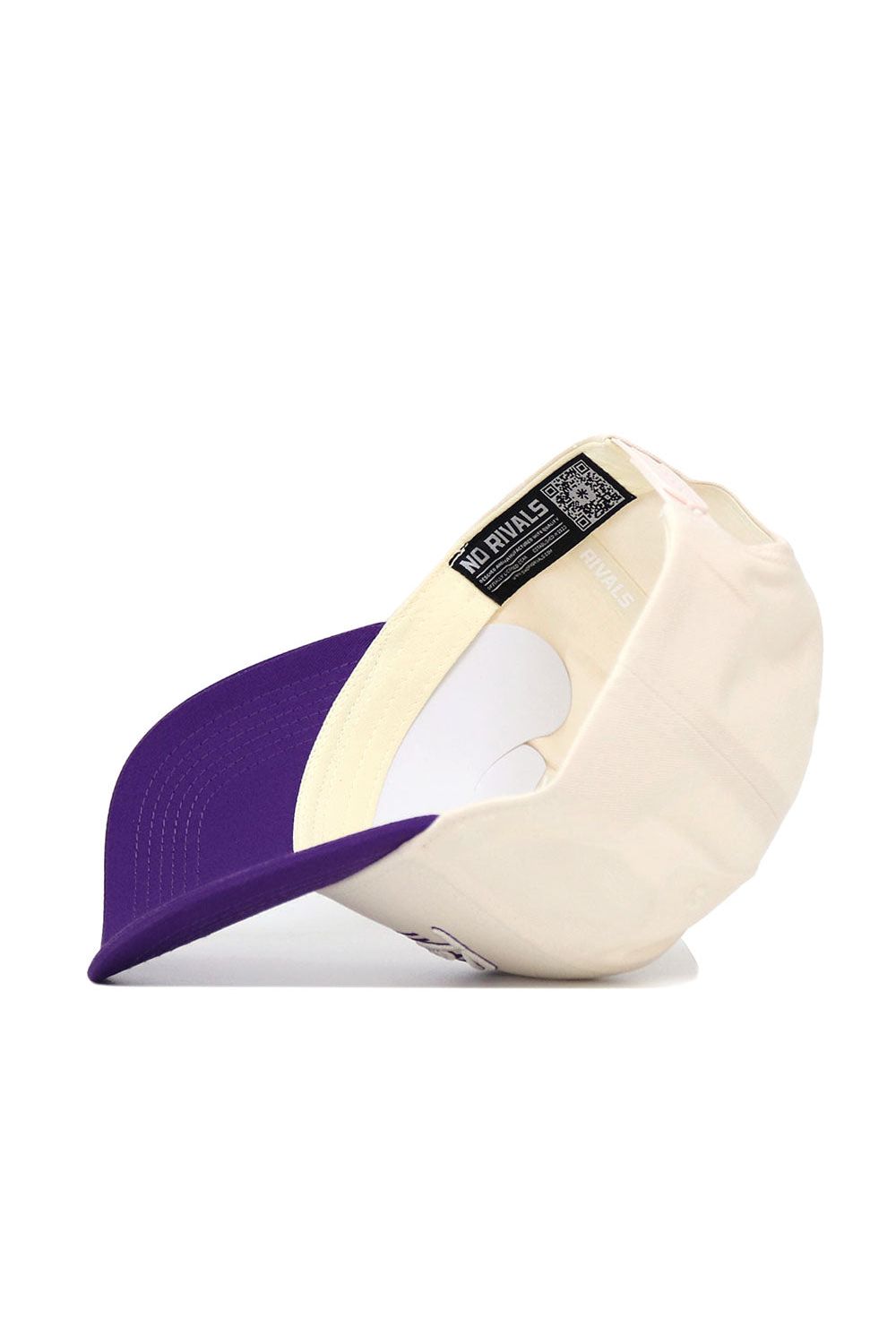 The Kansas State Triangle Game Cap Hat by No Rivals is shown cream-colored with a purple brim, displayed upside down to reveal the inside label reading "NO RIVALS" in white text on a black background.