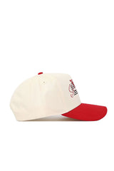 The No Rivals San Diego State Triangle Game Cap Hat is a cream snapback with a red brim and top button, shown from the side on a white background. Made of high-quality cotton, it has a structured fit and partial red and black embroidery on the front.