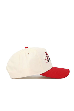 The No Rivals San Diego State Triangle Game Cap Hat is a cream snapback with a red brim and top button, shown from the side on a white background. Made of high-quality cotton, it has a structured fit and partial red and black embroidery on the front.