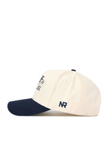 The No Rivals Georgia Tech Triangle Game Cap Hat is cream-colored with a navy brim and button. "NR" is embroidered in navy on the side, with partial navy designs visible on the front. Made from high-quality cotton.