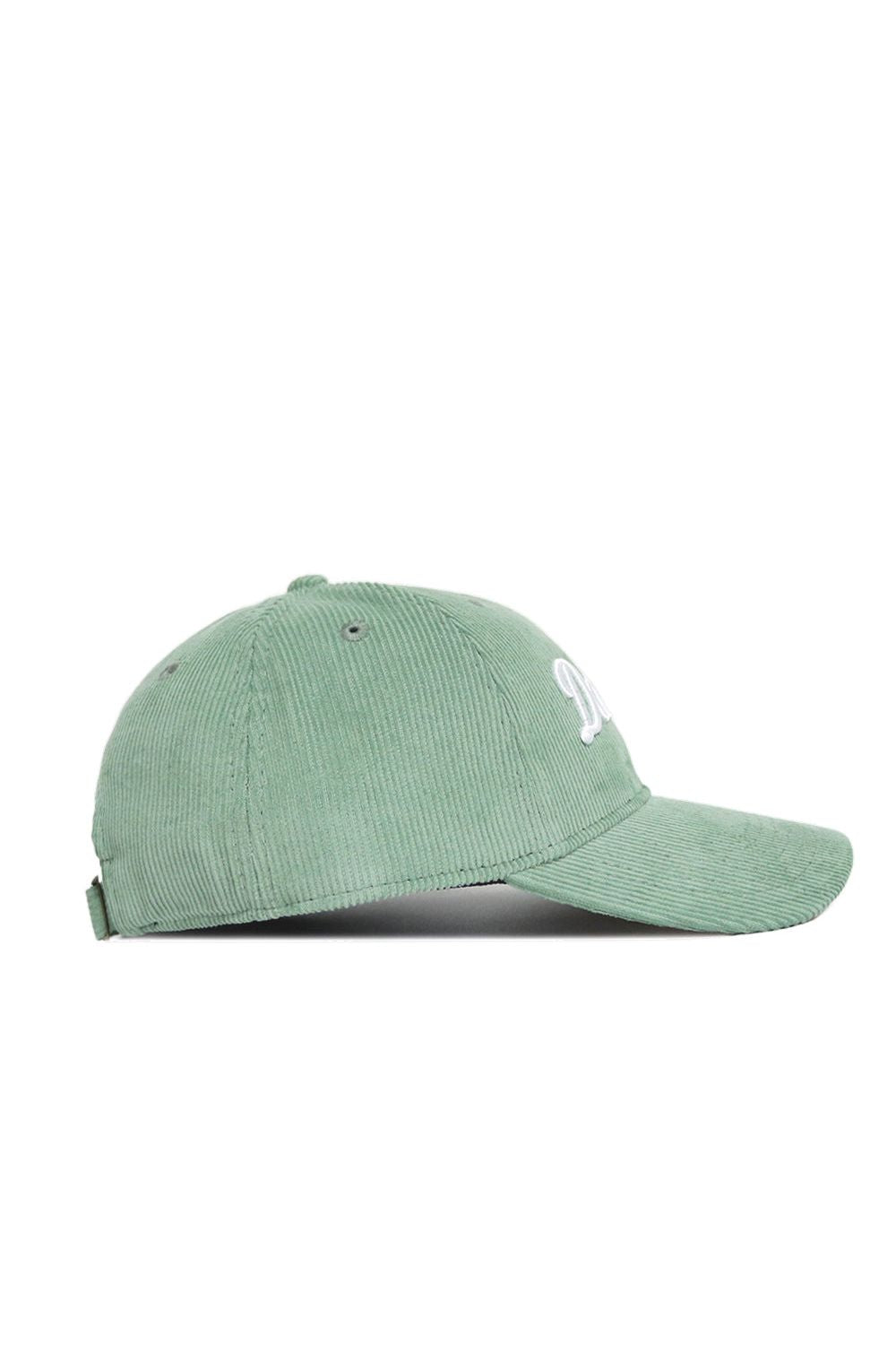 The Dallas Corduroy Hat by No Rivals features an unstructured 6-panel design in spring green, with partially visible white embroidered front lettering and an adjustable back strap.