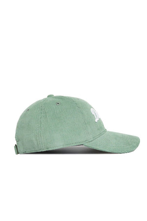 The Dallas Corduroy Hat by No Rivals features an unstructured 6-panel design in spring green, with partially visible white embroidered front lettering and an adjustable back strap.