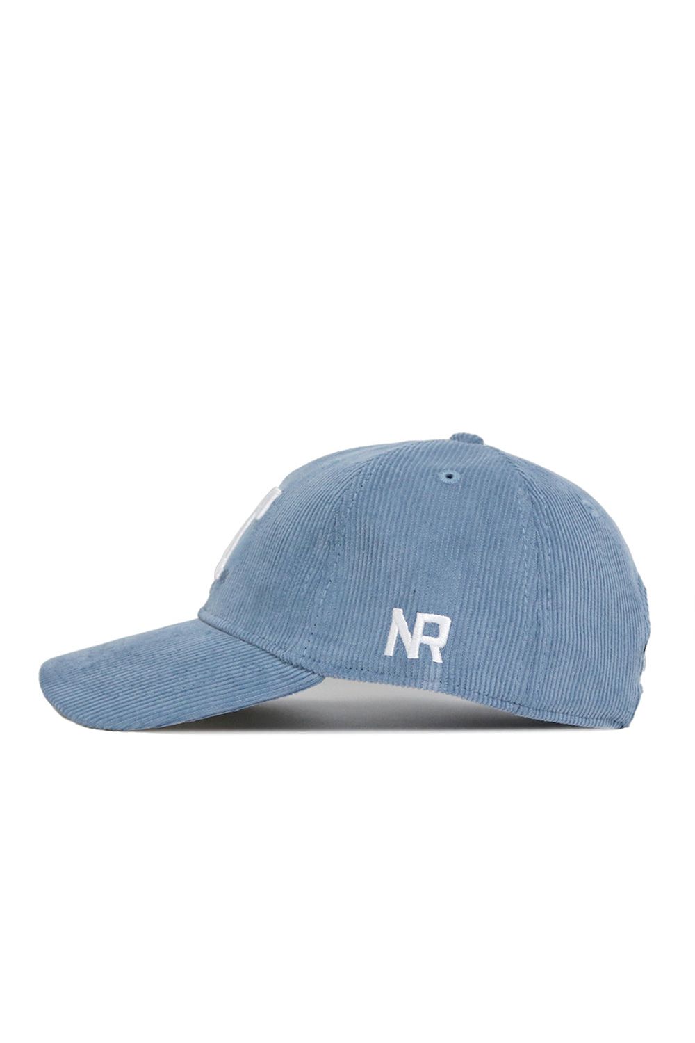 The No Rivals Tennessee Corduroy Hat in Sky Blue features an unstructured 6-panel design, curved brim, white embroidered NR letters on the side, an adjustable strap for a custom fit, and is shown in a left profile view.