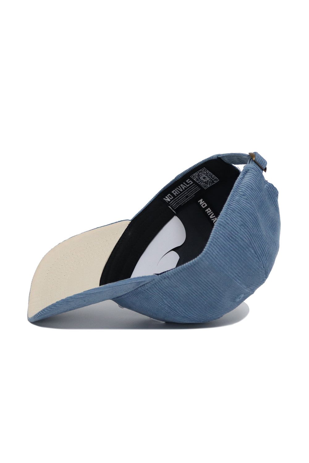 The Tennessee Corduroy Hat - Unstructured - Sky Blue by No Rivals is shown upside down, highlighting its 6-panel design, beige brim underside, black inner band with NO RIVALS text, and adjustable back strap.