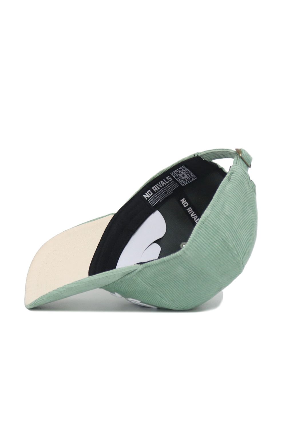 The Iowa Corduroy Hat from No Rivals’ Spring Showers Collection is pictured here in spring green, displayed upside down to reveal the beige underside of the brim and a black interior band featuring the “NO RIVALS” logo. This unstructured 6-panel snapback cap combines casual style and comfort, distinguished by its unique corduroy texture.