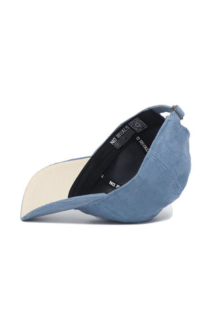 The No Rivals Kentucky Corduroy Hat - Unstructured - Sky Blue (B2B) is shown upside down, revealing its beige underside, black inner band with NO RIVALS text, and an adjustable back strap.