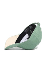 The No Rivals Tennessee Corduroy Hat – Unstructured in Spring Green features a 6-panel design, adjustable strap, and beige underbrim. Shown on its side, the inside label and strap are clearly visible.