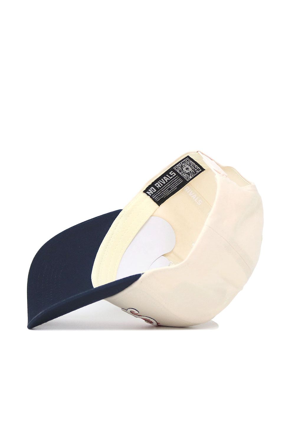 The Syracuse Triangle Game Cap Hat by No Rivals is a cream snapback with a navy blue brim, shown from below. Its structured fit includes an inner label reading "NO RIVALS" and a QR code on the sweatband.