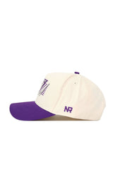 The No Rivals TCU Triangle Game Cap Hat is a cream cotton snapback with a purple brim, top button, and NR side initials. It features a structured fit and a purple and white embroidered front design.