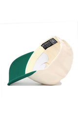 The No Rivals NDSU Triangle Game Cap Hat is shown inside-out on a white background, highlighting its structured fit, interior labels, stitching, and sweatband. This cream cap with a green brim is made from high-quality cotton and features an adjustable snapback.