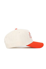 The No Rivals Oklahoma State Triangle Game Cap Hat features a cream crown, bright red brim, small red top button, partially visible front logo in profile view, and a structured fit that maintains its shape.