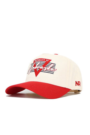 The No Rivals Nebraska Triangle Game Cap Hat is a high quality cotton baseball cap in white and red, featuring University of Nebraska and Nebraska on the front, a red N logo on the side, structured fit, and classic snapback closure.
