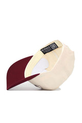 The Mississippi State Triangle Game Cap Hat by No Rivals is shown upside down, displaying its label and QR code inside the beige cotton snapback with a maroon brim for a comfortable, structured fit.