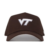 The Virginia Tech Americano Hat is a brown snapback crafted from high-quality cotton, featuring a white embroidered VT logo on the front. Officially licensed for authentic style.