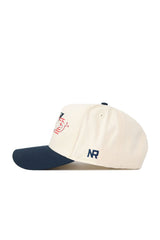 The No Rivals DBU Triangle Game Cap Hat is cream with a navy brim, red and navy embroidered graphics on the front, and "NR" stitched on the side. This snapback offers a structured, comfortable fit for daily wear.