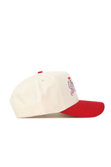 The No Rivals SMU Triangle Game Cap Hat is a cream snap back with a red brim, structured fit, and features a multicolored embroidered seahorse logo on the front panel. Shown in profile.
