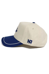 The No Rivals Rice Owls ALOYO Hat is a high-quality beige cotton snapback featuring a blue brim, structured fit, and blue NR initials embroidered on the side. The hat also has a blue underside brim and top button for a stylish touch.