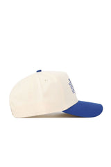 The No Rivals Rice Triangle Game Cap Hat is a cream snapback with a blue brim, shown from the side. It features ventilation eyelets, a structured fit, and part of a blue graphic or text on the front panel.