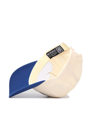 The Rice Triangle Game Cap Hat by No Rivals features a structured cream fit, blue brim, white sweatband, and a NO RIVALS tag with QR code sewn into the inner lining, as seen from beneath.