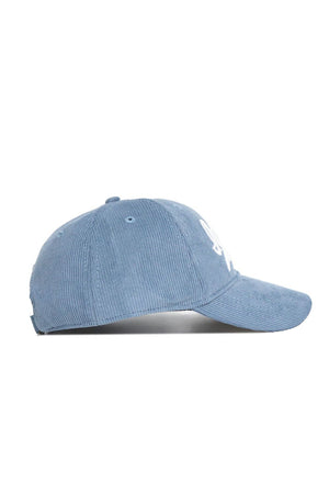 The No Rivals Iowa Corduroy Hat from the Spring Showers Collection is shown in sky blue corduroy, viewed from the side with a curved brim and a partially visible white embroidered design on the front. This unstructured 6-panel cap features an adjustable strap for a comfortable, customized fit.