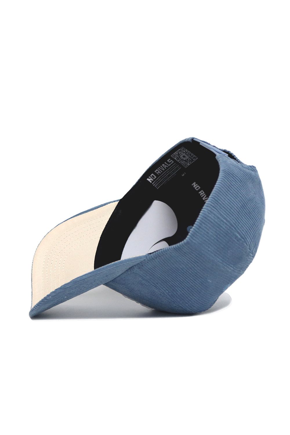 The Texas A&M Corduroy Hat - Structured - Sky Blue by No Rivals is shown upside down, revealing its off-white brim underside and inner black band featuring “NO RIVALS” printed on it.