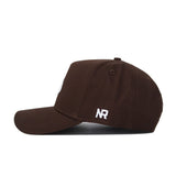 The Texas State Americano Hat is a brown snapback seen from the side, with white embroidered "NR" near the back and crafted from high-quality cotton for a structured fit.