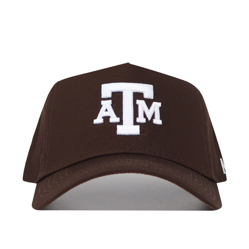 The Texas A&M Americano Hat is a brown snapback baseball cap with a white embroidered ATM logo on the front, made from soft cotton and officially licensed to show your authentic Aggie pride.