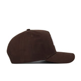 The Texas A&M Americano Hat is a brown cotton baseball cap with a curved brim and top button, shown in side profile. It appears plain with no visible logos or designs on the visible side.